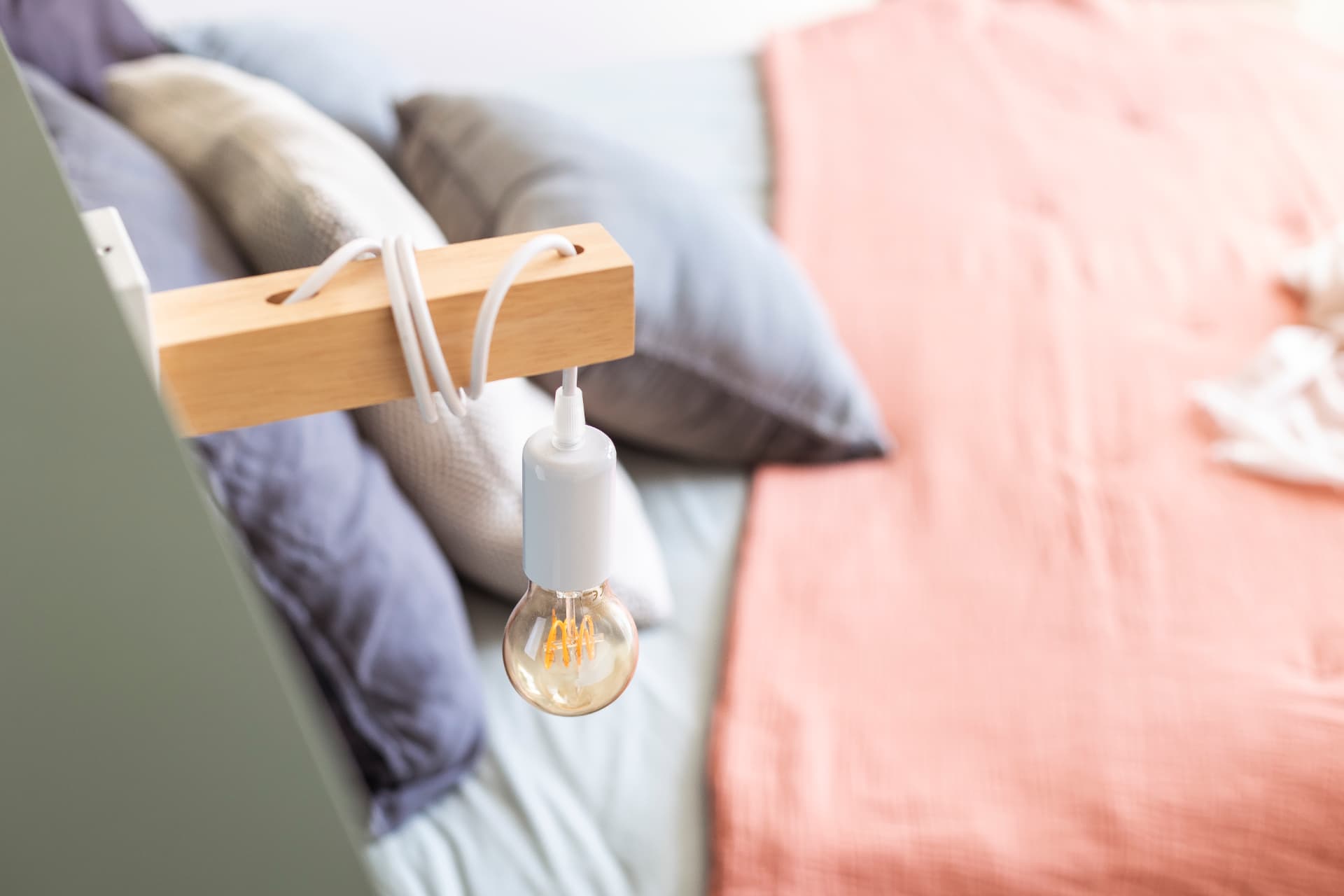 Détail d'une liseuse en bois fixée sur la tête de lit Détail d'une liseuse en bois fixée sur la tête de lit