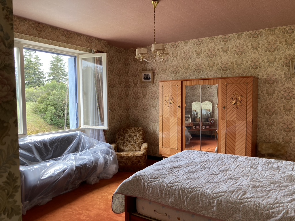 Avant travaux : chambre d'époque avec papier peint à motifs, moquette orange et armoire en marqueterie — projet à Saint-Gilles-les-Bains, Ouest de La Réunion