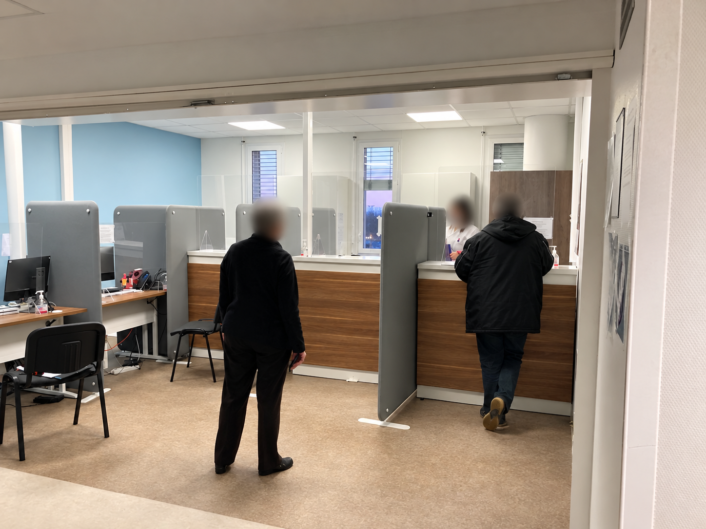 Avant travaux : accueil administratif avec guichets en bois, cloisons grises mobiles et écrans de protection — secrétariat médical à Toulouse