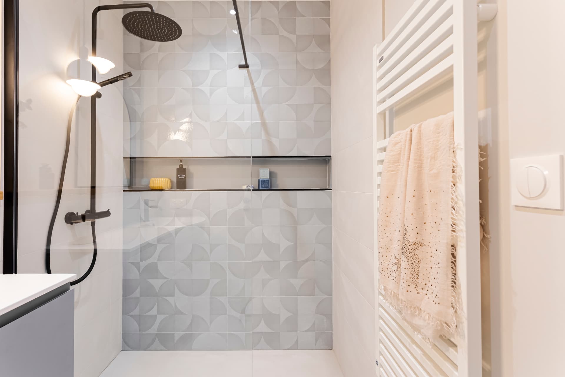 Douche à l'italienne avec niche intégrée et carrelage en relief, sèche-serviettes blanc Douche à l'italienne avec niche intégrée et carrelage en relief, sèche-serviettes blanc