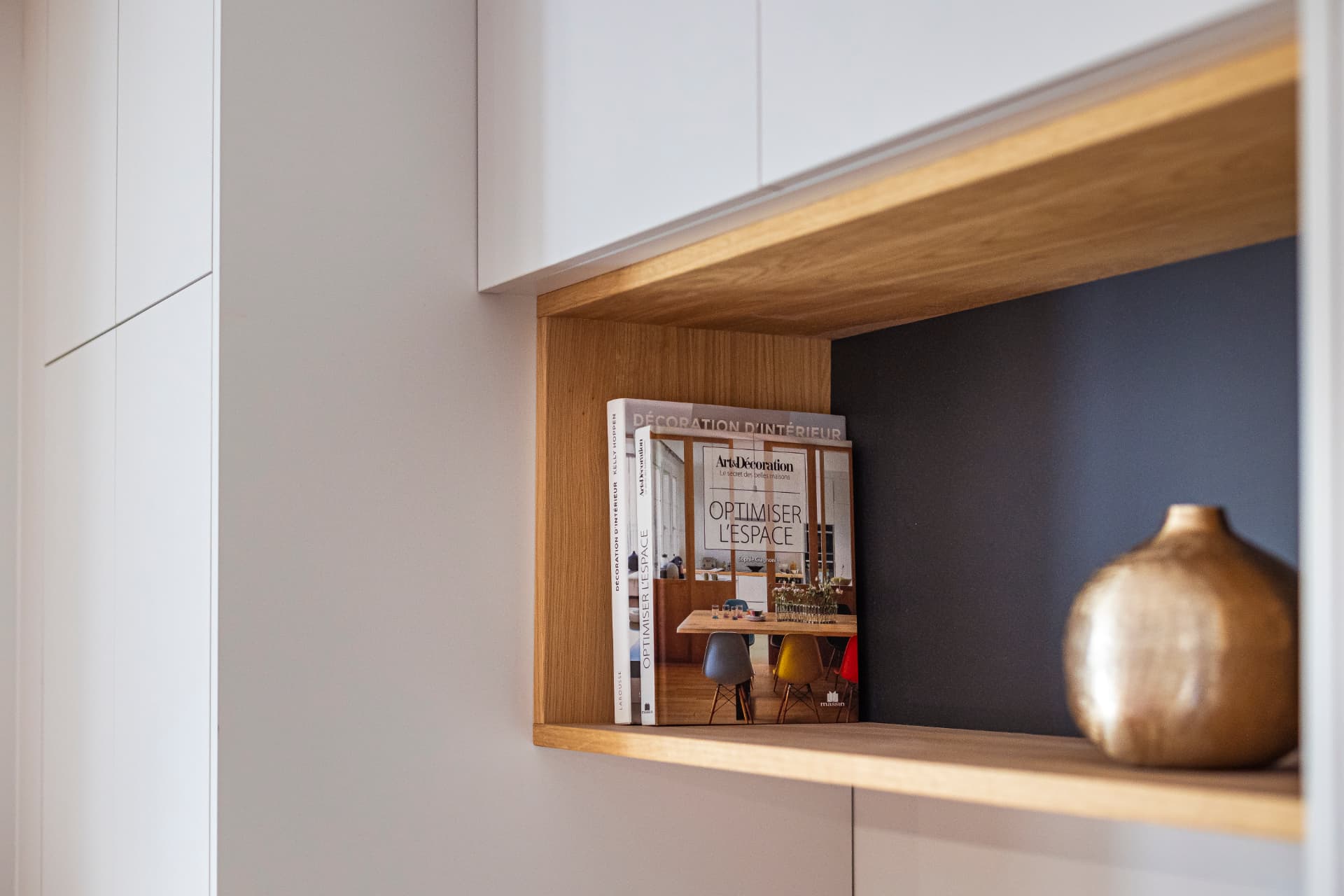 Détail d'une niche en chêne avec livres de décoration et vase doré Détail d'une niche en chêne avec livres de décoration et vase doré