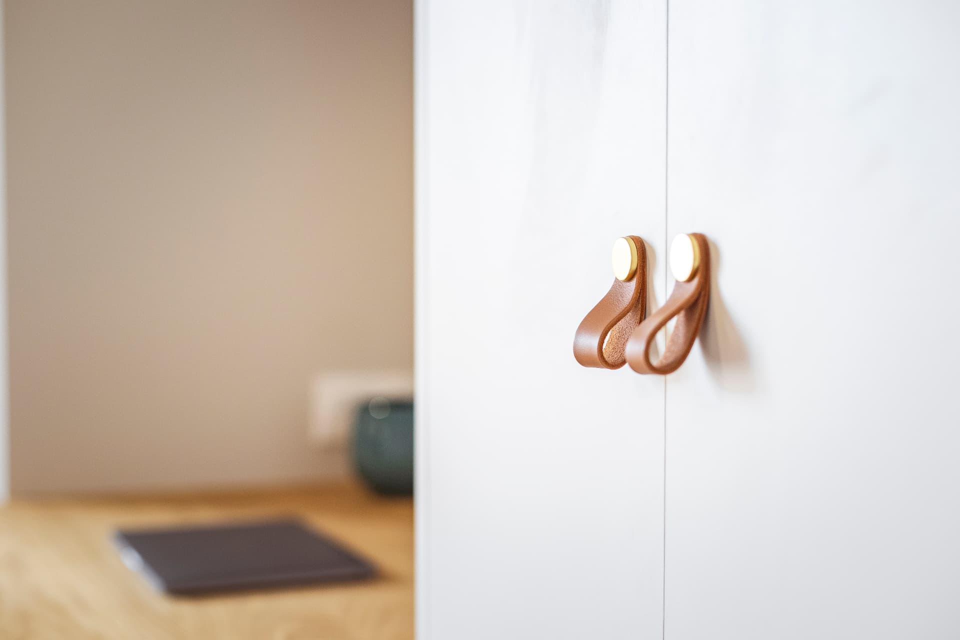 Détail des poignées en cuir et laiton d'un placard sur mesure Détail des poignées en cuir et laiton d'un placard sur mesure