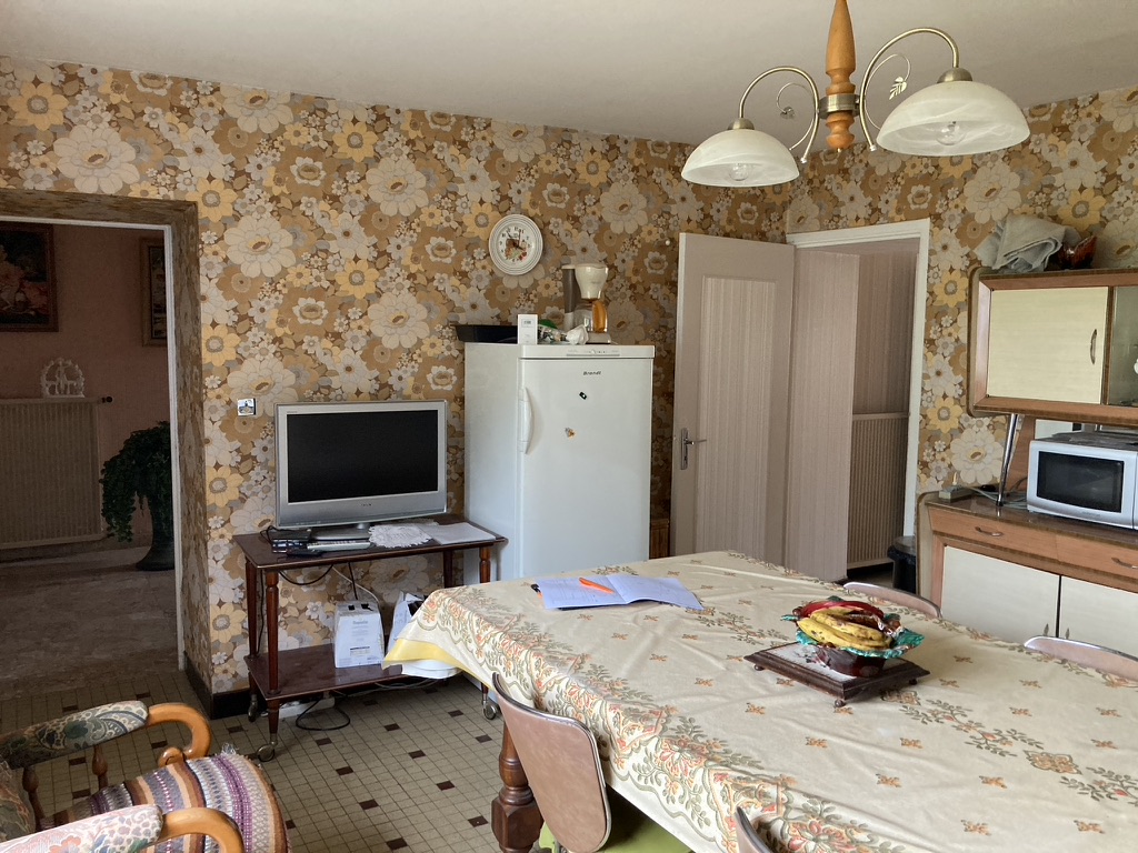 Avant travaux : salle à manger d'époque avec papier peint à grandes fleurs, carrelage à petits carreaux et mobilier ancien — projet à La Saline-les-Bains, Ouest de La Réunion