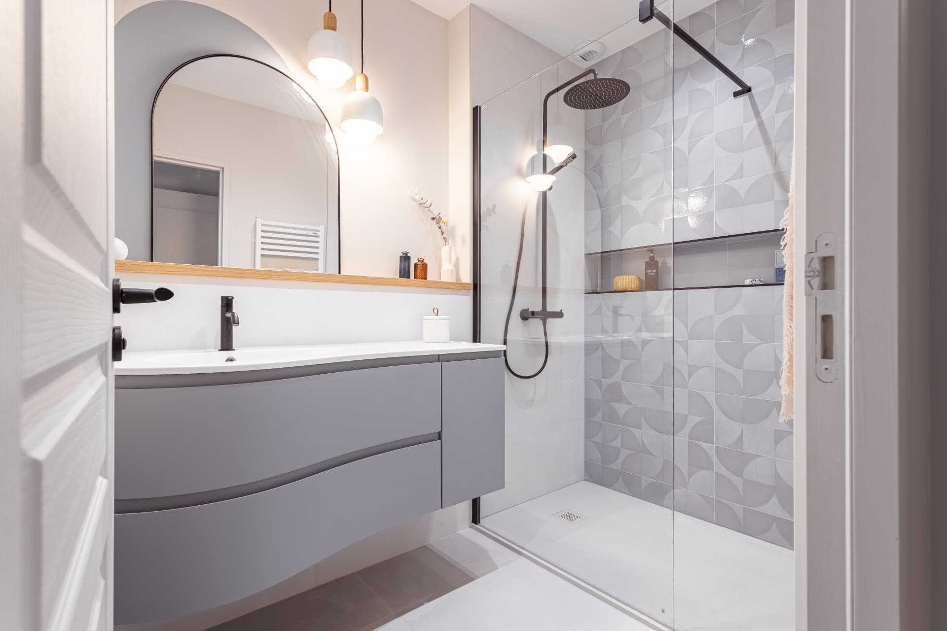 Salle de bain avec douche à l'italienne, carrelage graphique en relief et robinetterie noire Salle de bain avec douche à l'italienne, carrelage graphique en relief et robinetterie noire